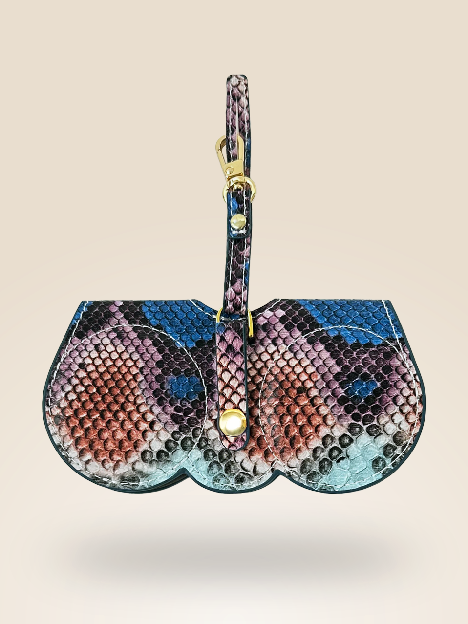 Back view of a stylish eyewear case charm in a python-inspired pattern with shades of blue, pink, and black. Made from vegan leather, it features a gold-tone clasp and a secure snap button closure on the strap for easy attachment to bags. Designed for both function and fashion.